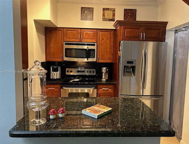 kitchen with kitchen peninsula, crown molding, stainless steel appliances, and dark stone countertops