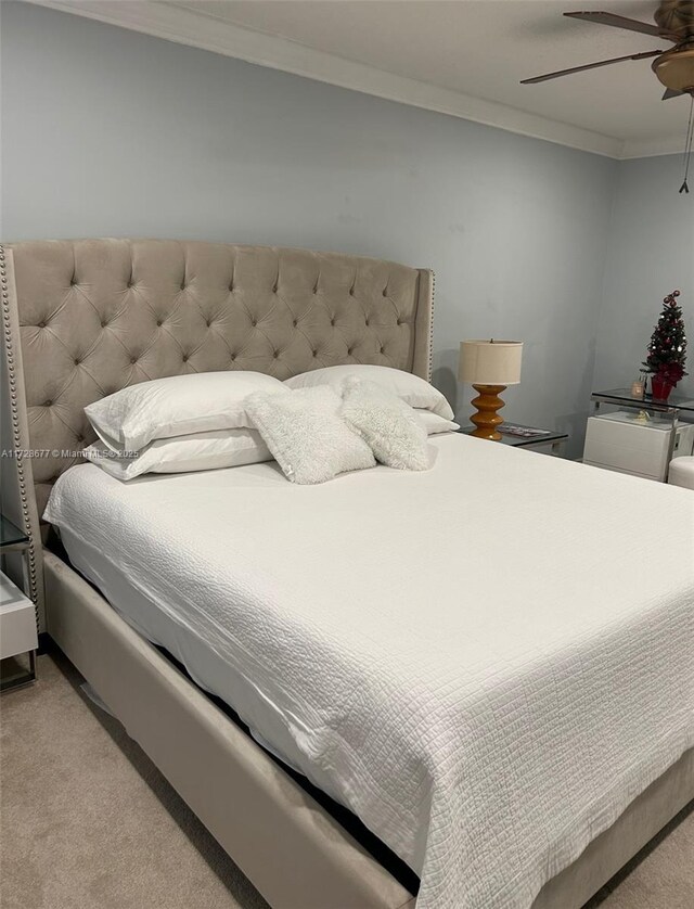 carpeted bedroom with ceiling fan and crown molding