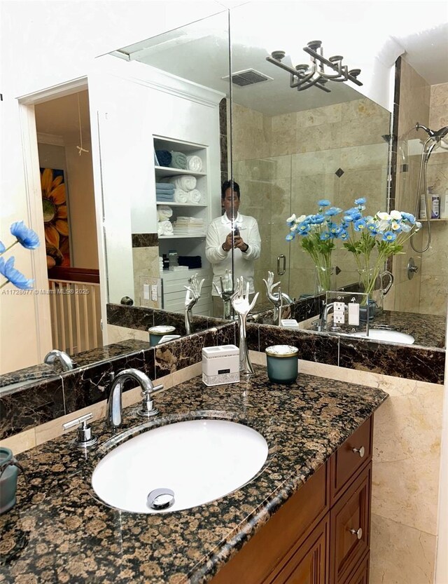 bathroom featuring vanity, ornamental molding, and an enclosed shower