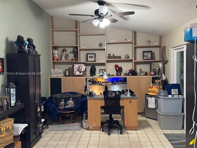 tiled office space featuring ceiling fan, a textured ceiling, and lofted ceiling