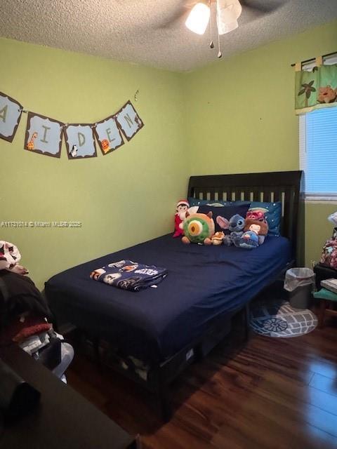 bedroom featuring ceiling fan, a textured ceiling, and hardwood / wood-style floors