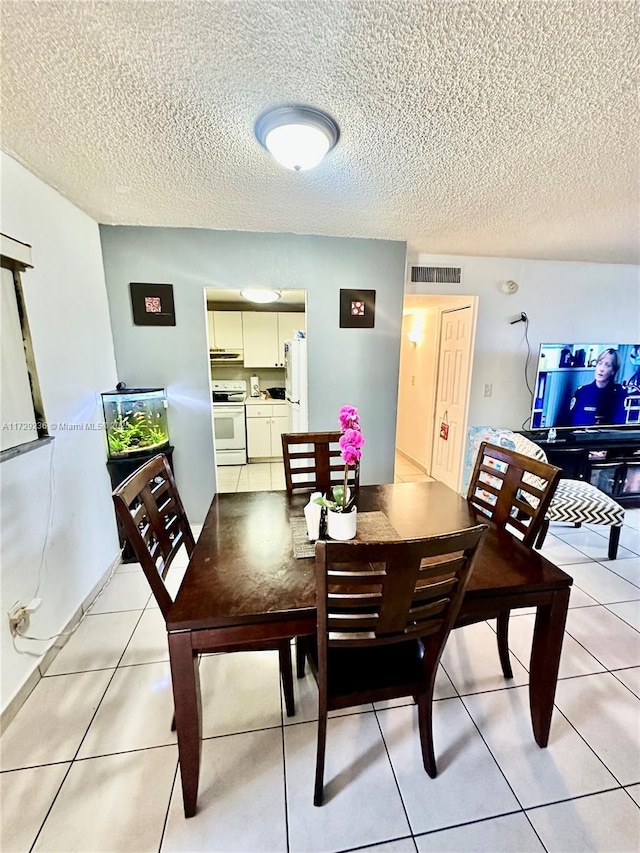 tiled dining area with a textured ceiling