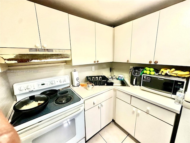 kitchen featuring sink, white cabinetry, white appliances, and light tile patterned flooring