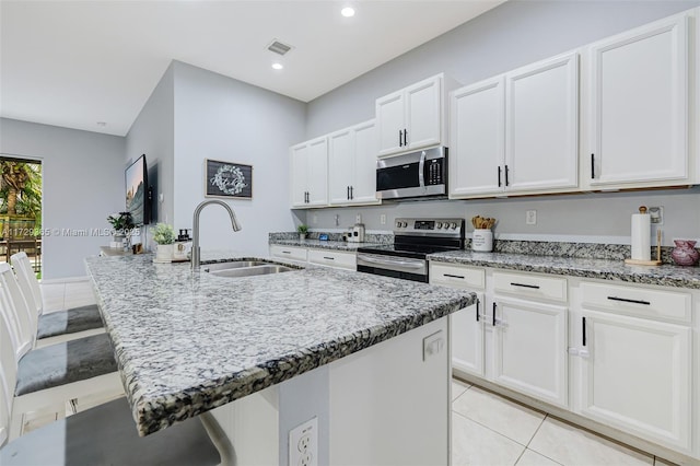 kitchen featuring sink, appliances with stainless steel finishes, and an island with sink