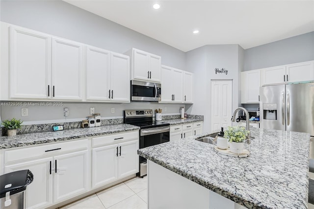 kitchen featuring sink, light stone counters, a kitchen island with sink, and appliances with stainless steel finishes