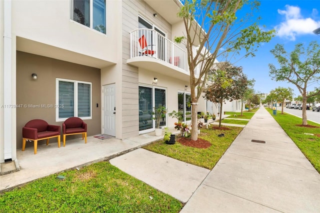 exterior space featuring a balcony and a yard