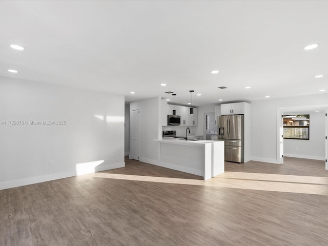 unfurnished living room with sink and light hardwood / wood-style floors