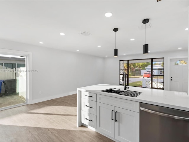 kitchen with light hardwood / wood-style floors, hanging light fixtures, stainless steel dishwasher, white cabinets, and sink