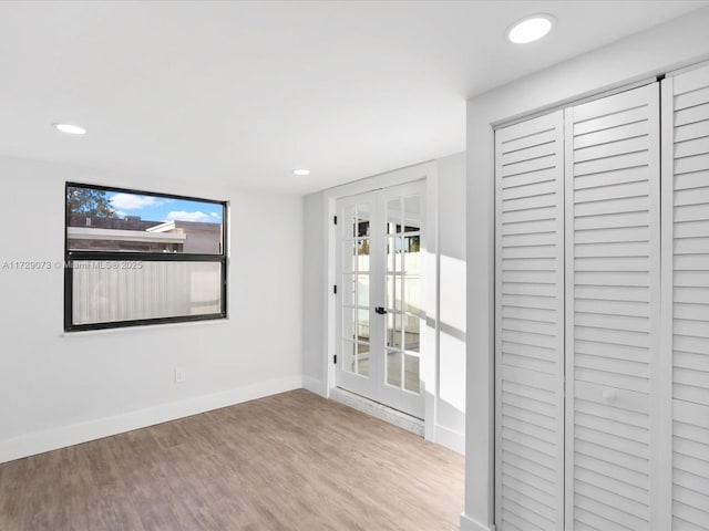 spare room featuring light wood-type flooring and french doors