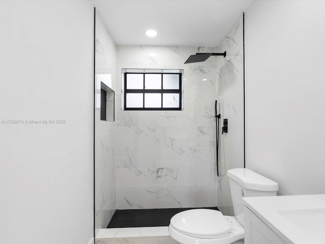 bathroom with vanity, toilet, and a tile shower