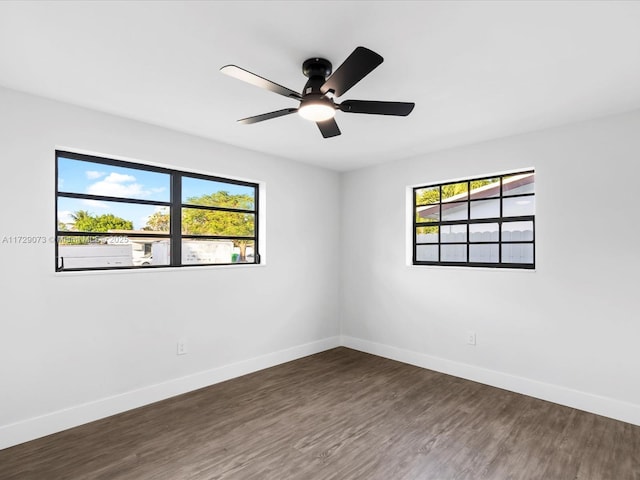 empty room with dark wood-type flooring and ceiling fan