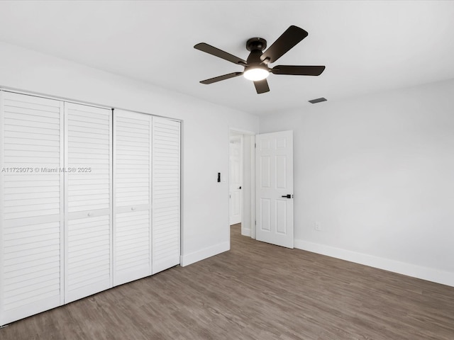 unfurnished bedroom with hardwood / wood-style flooring, a closet, and ceiling fan