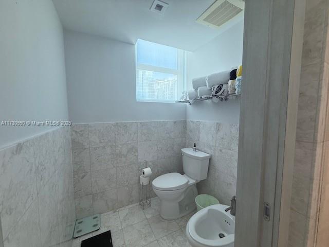 1331 Brickell Bay Dr Unit 1602, Miami, FL 33131 - bathroom with a bidet, tile walls, toilet, and a wainscoted wall