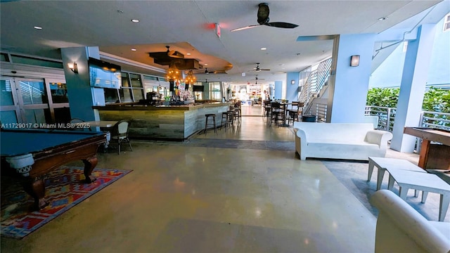 interior space with billiards, concrete floors, and ceiling fan