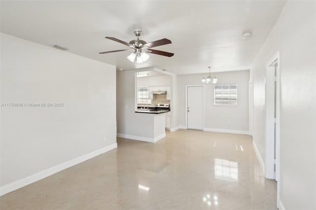 unfurnished living room featuring ceiling fan with notable chandelier