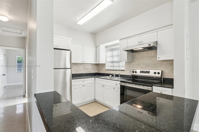 kitchen featuring tasteful backsplash, white cabinetry, dark stone counters, sink, and stainless steel appliances