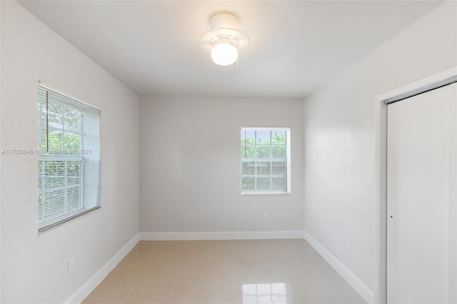 unfurnished bedroom featuring multiple windows and a closet