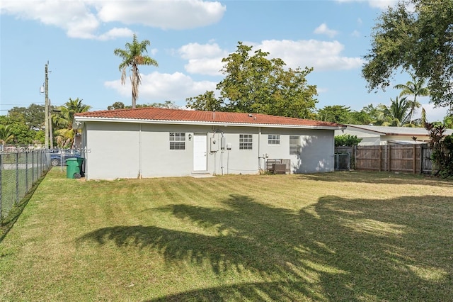 rear view of property with a lawn