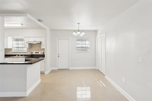 kitchen with stainless steel electric stove, pendant lighting, white cabinets, and decorative backsplash