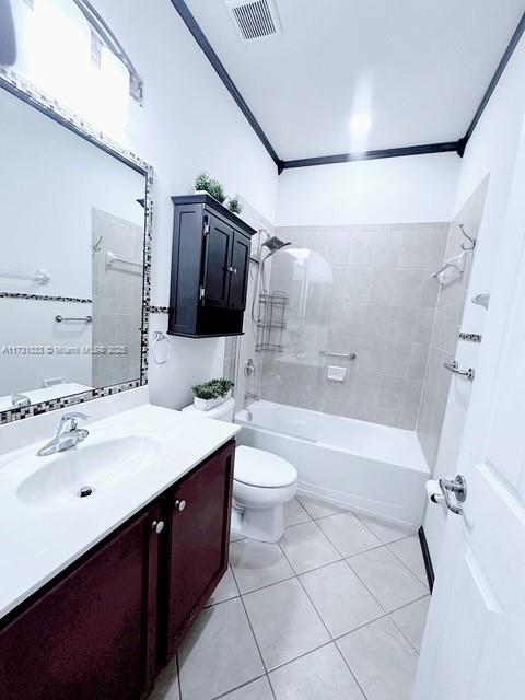 full bathroom with toilet, vanity, ornamental molding, and tiled shower / bath