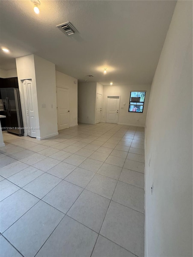 tiled spare room with a textured ceiling