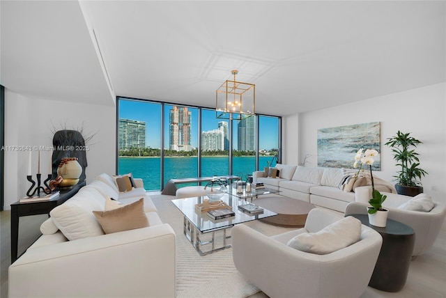 living room featuring a notable chandelier, a wall of windows, and a water view