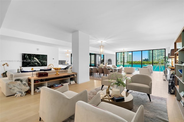 living room with expansive windows and light hardwood / wood-style floors