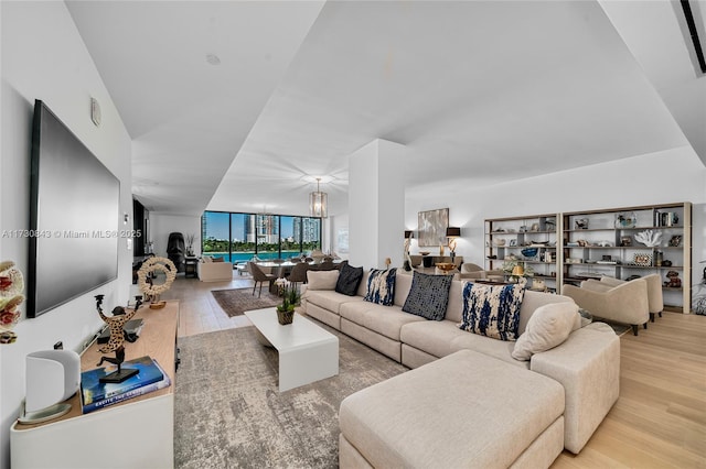 living room with an inviting chandelier and light hardwood / wood-style flooring