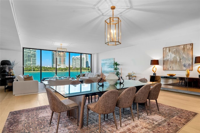 dining room featuring a wall of windows, light hardwood / wood-style flooring, and a notable chandelier