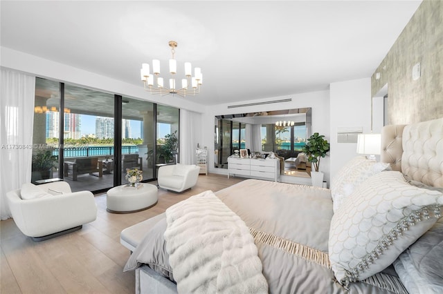 bedroom with hardwood / wood-style flooring, access to outside, and a chandelier