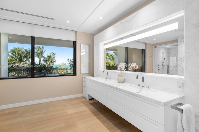 bathroom with hardwood / wood-style flooring, vanity, and walk in shower