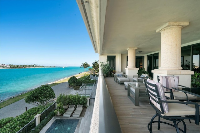 balcony with a water view, outdoor lounge area, and a beach view