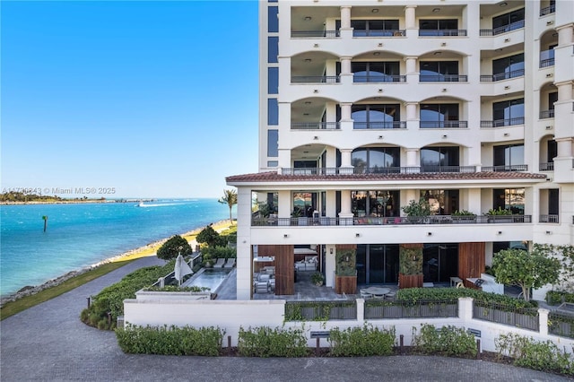 view of building exterior with a beach view and a water view