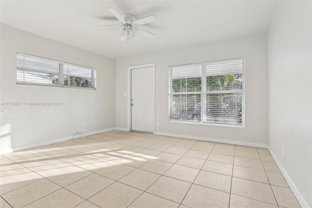 tiled empty room with plenty of natural light and ceiling fan