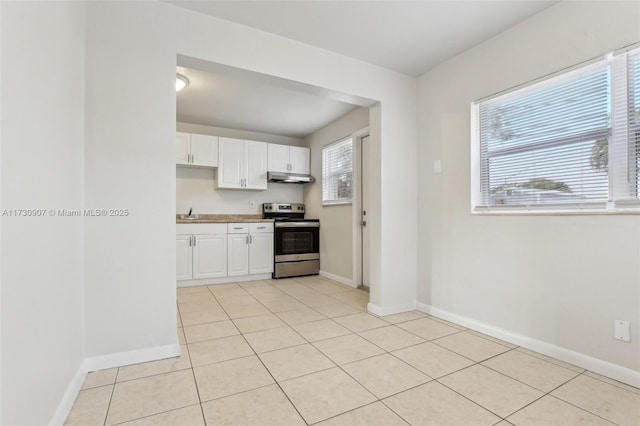 kitchen featuring white cabinets, electric range, and light tile patterned floors