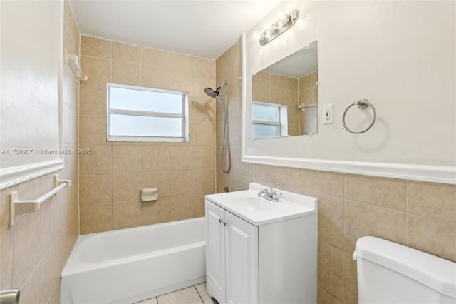 full bathroom featuring toilet, tiled shower / bath combo, tile walls, tile patterned floors, and vanity