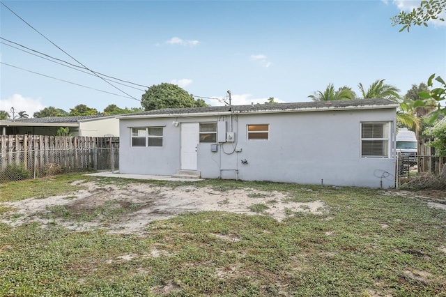 rear view of property featuring a lawn