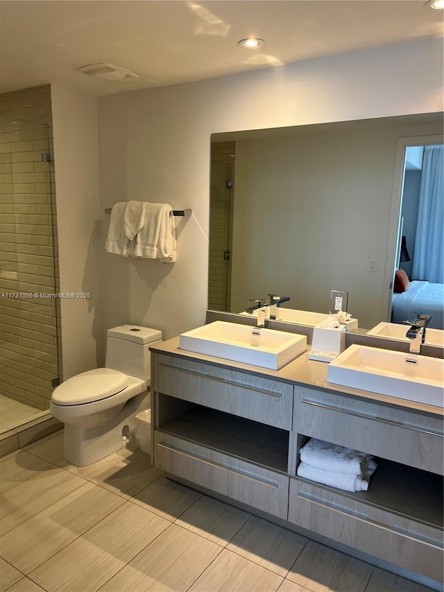 bathroom featuring vanity, a shower with door, and toilet