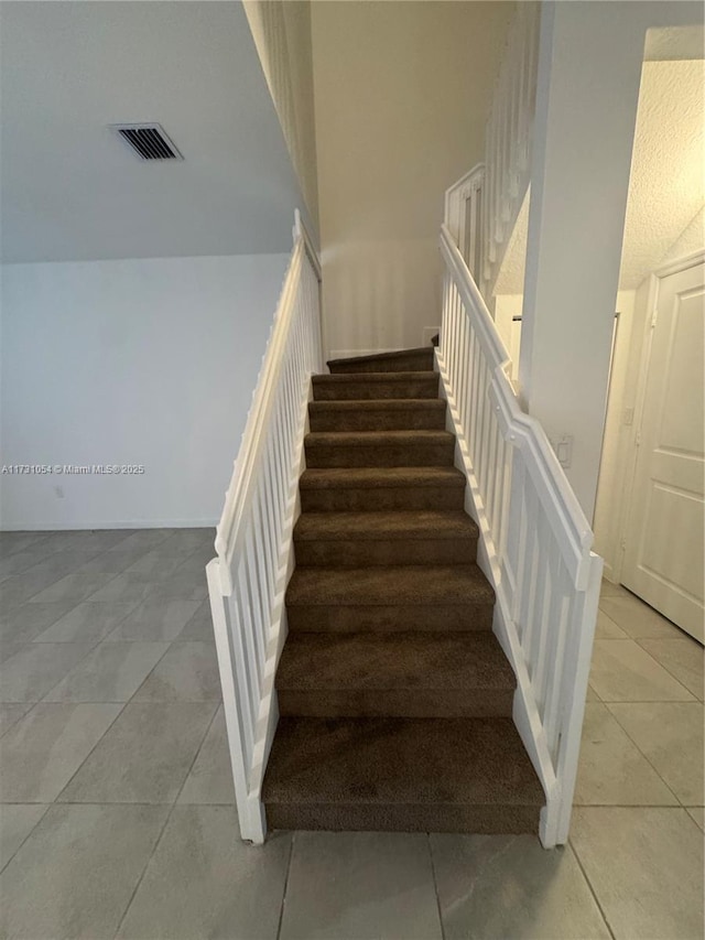 stairs with tile patterned flooring