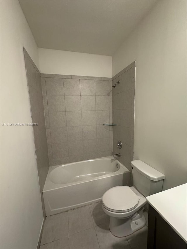 full bathroom featuring tiled shower / bath, vanity, toilet, and tile patterned flooring