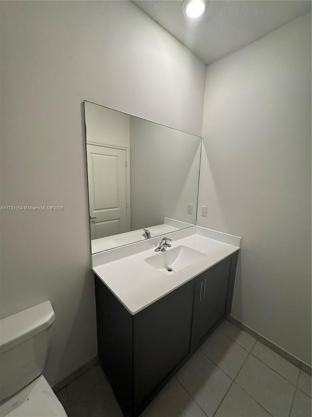 bathroom featuring vanity, tile patterned flooring, and toilet