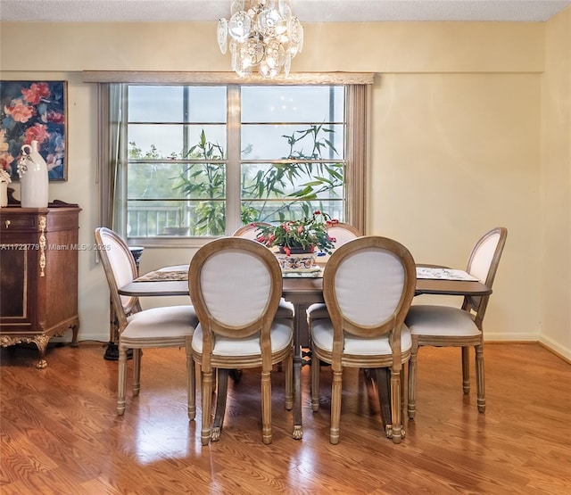 dining room featuring wood-type flooring, an inviting chandelier, and a healthy amount of sunlight