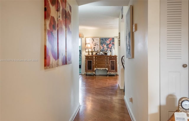 hall with a textured ceiling and dark hardwood / wood-style flooring