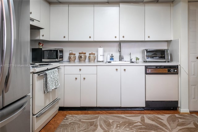 kitchen featuring sink, stainless steel appliances, white cabinets, and dark hardwood / wood-style floors