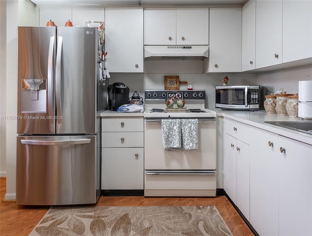 kitchen with white cabinets, light hardwood / wood-style floors, and appliances with stainless steel finishes