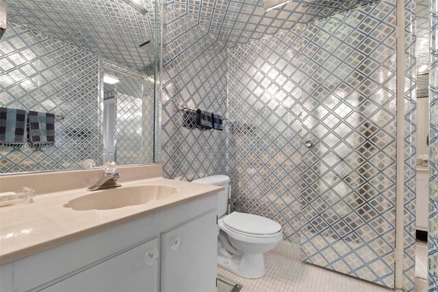 bathroom featuring tile walls, toilet, vanity, and tile patterned flooring