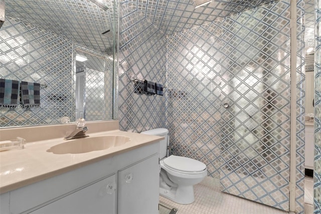 bathroom featuring vanity, tile walls, tile patterned floors, and toilet