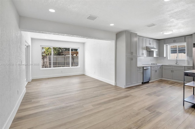 kitchen with sink, a textured ceiling, and gray cabinetry