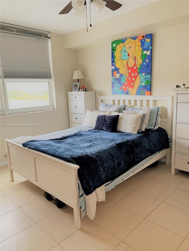 tiled bedroom featuring ceiling fan