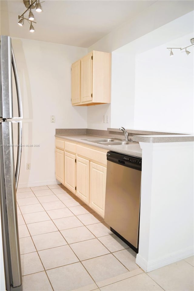 kitchen featuring a sink, appliances with stainless steel finishes, light tile patterned flooring, and light brown cabinetry